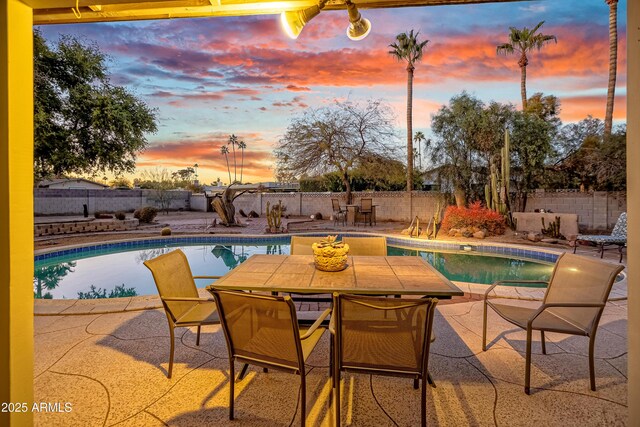 pool at dusk with a patio