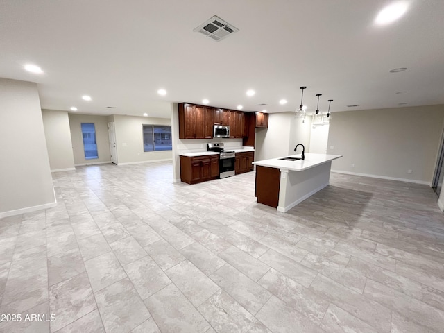 kitchen featuring hanging light fixtures, a kitchen island with sink, sink, and stainless steel appliances