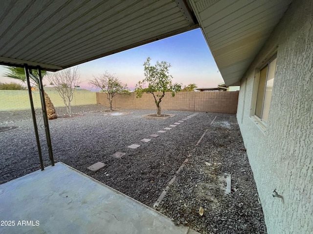 yard at dusk featuring a patio area