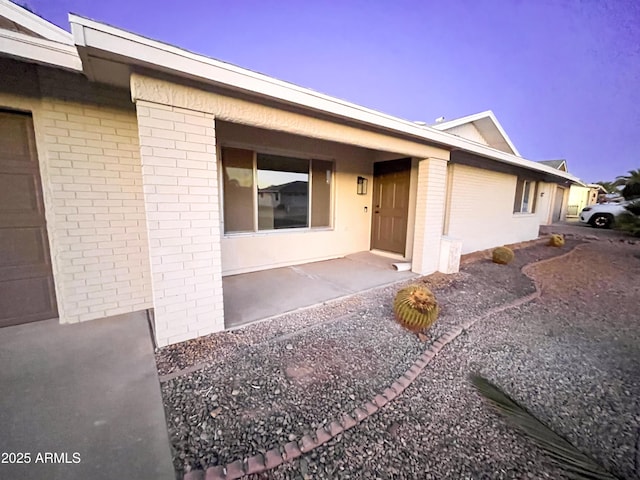 exterior entry at dusk with a patio area