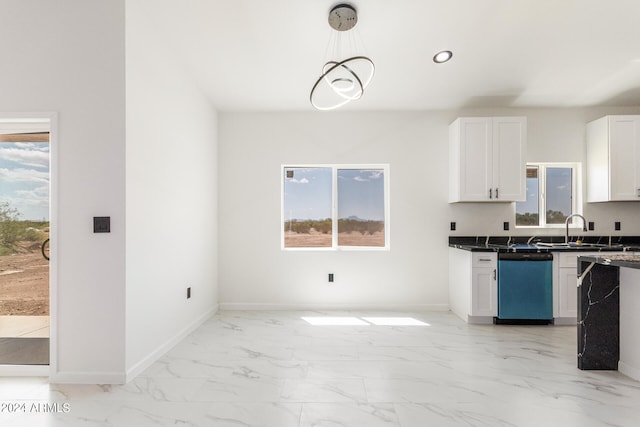 kitchen featuring light tile patterned floors, stainless steel dishwasher, and a healthy amount of sunlight