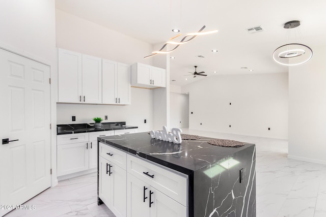 kitchen with a center island, lofted ceiling, white cabinets, and light tile patterned floors