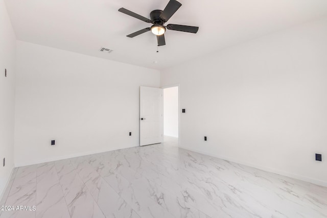 unfurnished room with marble finish floor, visible vents, ceiling fan, and baseboards