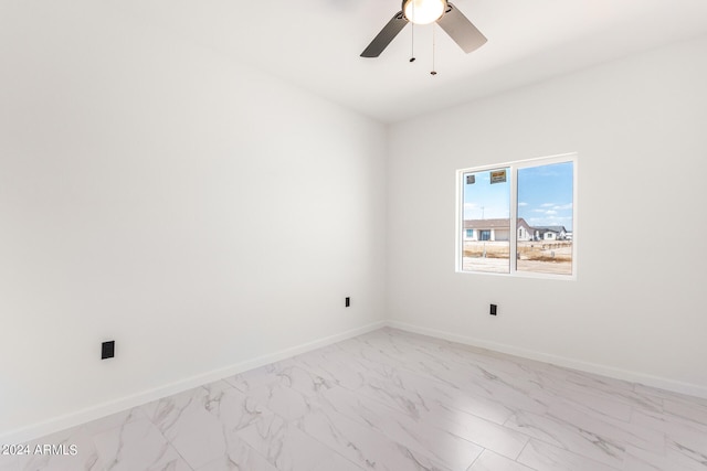 spare room with ceiling fan and light tile patterned floors