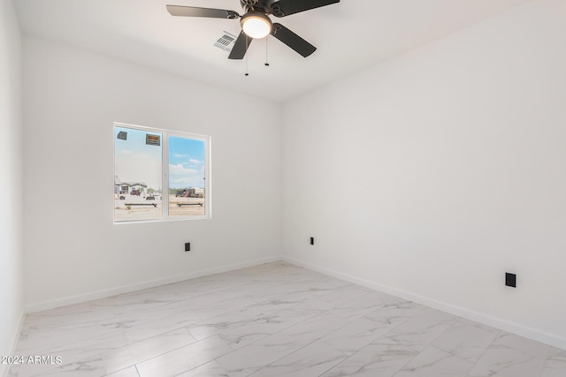 spare room featuring marble finish floor, visible vents, baseboards, and a ceiling fan