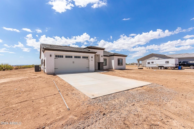 view of front of home featuring stucco siding, an attached garage, cooling unit, driveway, and a tiled roof