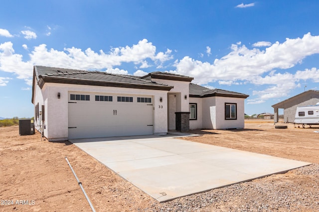 view of front of property with a garage and central AC