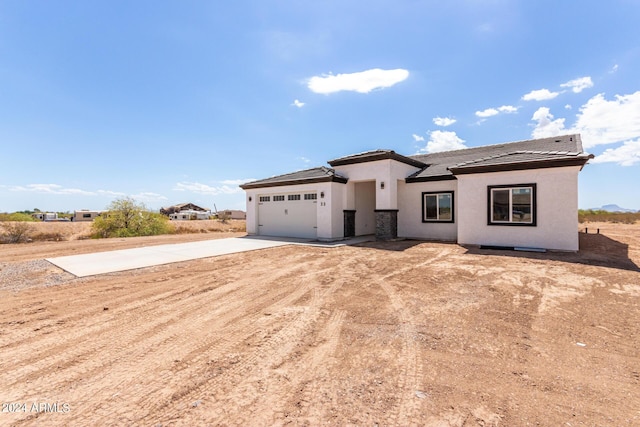 view of front facade with driveway, an attached garage, and stucco siding