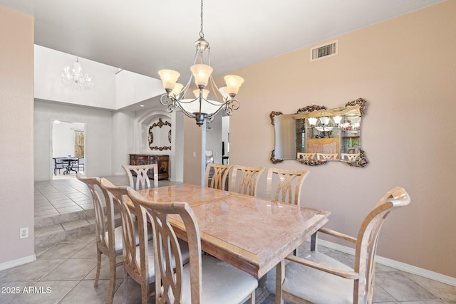 tiled dining area featuring an inviting chandelier