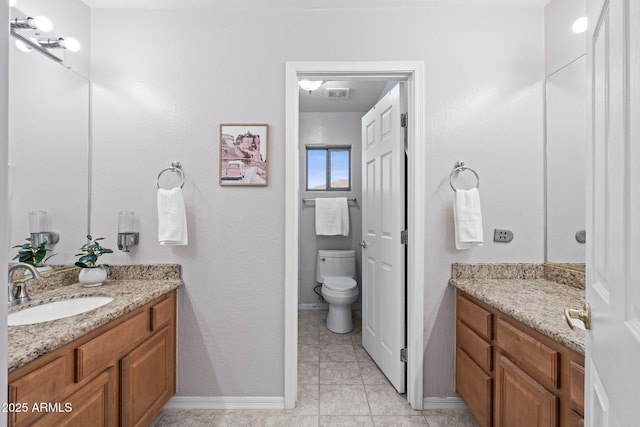 bathroom featuring vanity, tile patterned flooring, and toilet