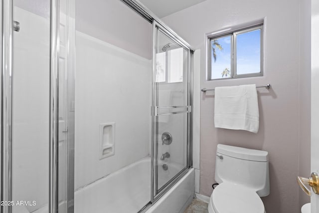 bathroom featuring shower / bath combination with glass door and toilet