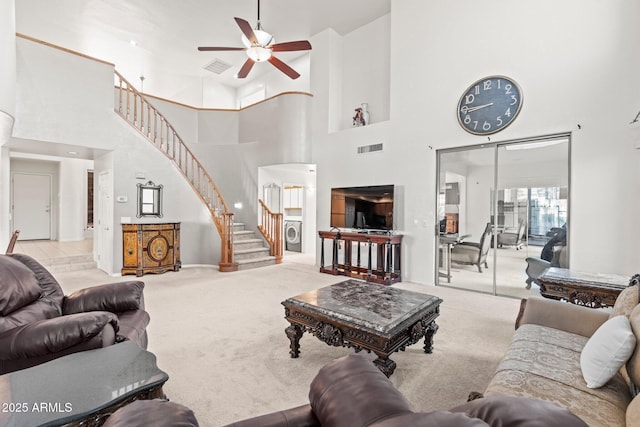 living room with ceiling fan, light colored carpet, and washer / clothes dryer