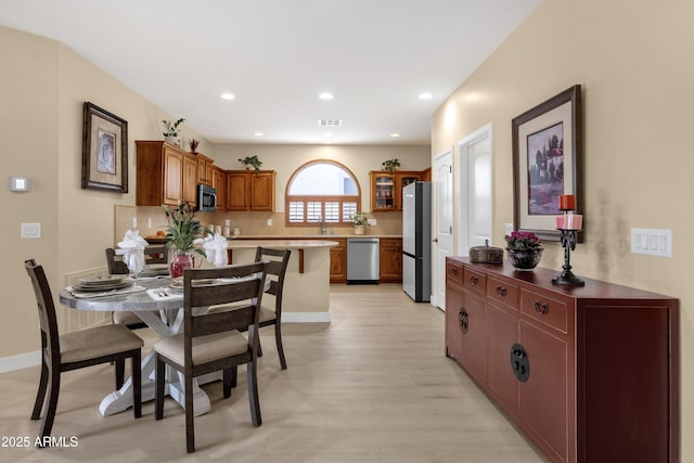 dining space featuring light wood-style floors, baseboards, and recessed lighting