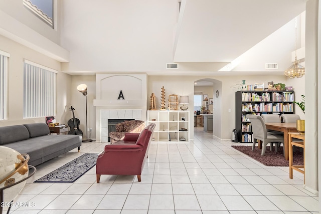 1451 E S Fork Dr, Phoenix, AZ 85048 - living area with high vaulted ceiling, arched walkways, a fireplace, light tile patterned flooring, and baseboards