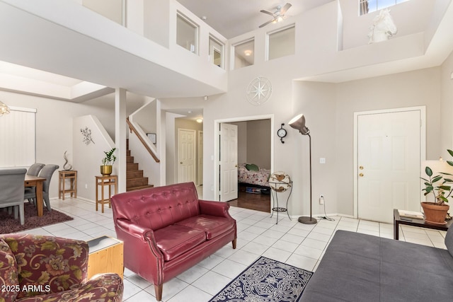 1451 E S Fork Dr, Phoenix, AZ 85048 - living area with a towering ceiling, light tile patterned flooring, stairway, a ceiling fan, and baseboards