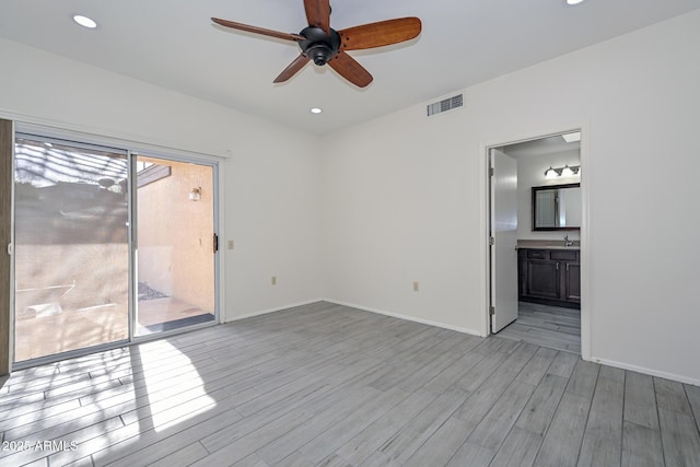 empty room featuring ceiling fan, light wood-type flooring, and sink