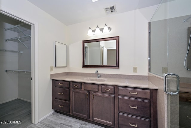 bathroom with vanity and a shower with door