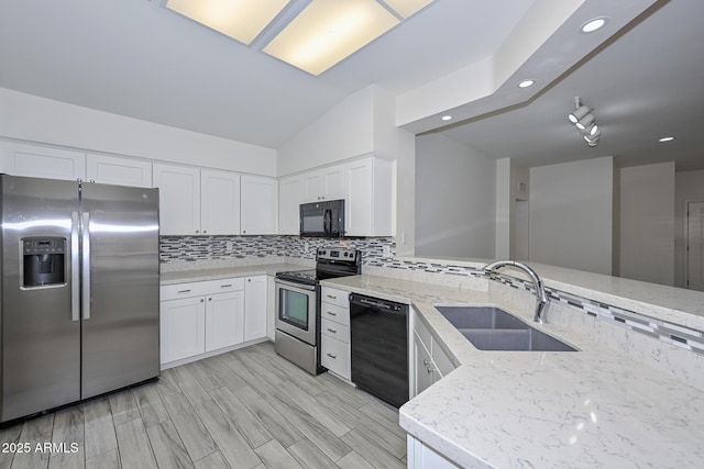 kitchen with white cabinets, sink, kitchen peninsula, and black appliances