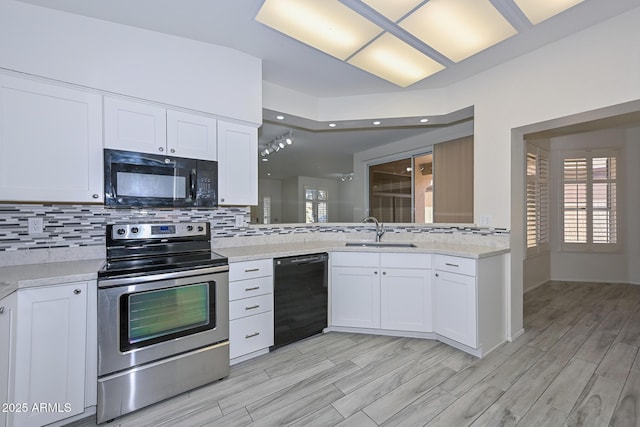 kitchen with sink, backsplash, white cabinetry, and black appliances