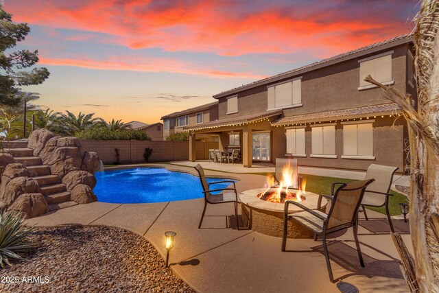 view of swimming pool with a fenced backyard, a fenced in pool, a fire pit, and a patio