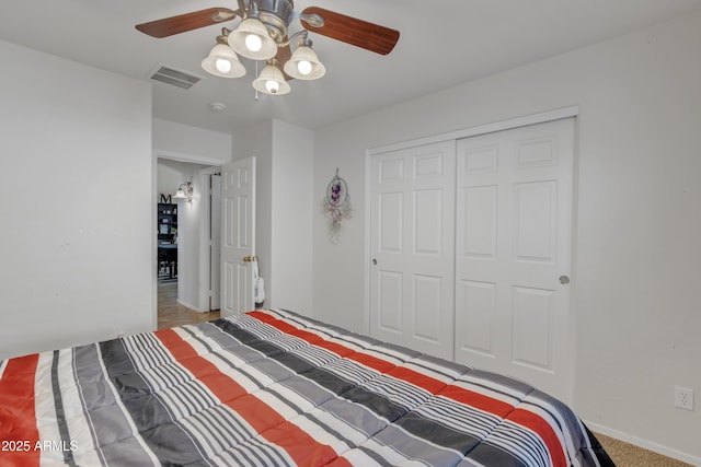 bedroom featuring a closet, carpet flooring, visible vents, baseboards, and ceiling fan