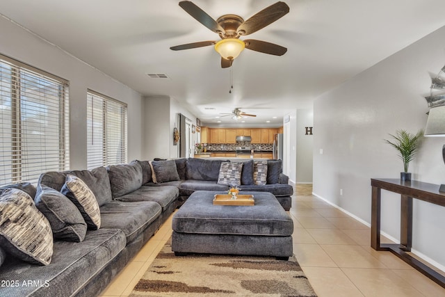 living room with light tile patterned floors, baseboards, visible vents, and a ceiling fan