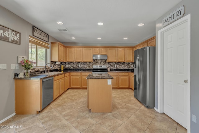 kitchen with visible vents, stainless steel appliances, under cabinet range hood, a sink, and a center island