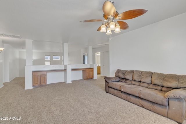 living room featuring a ceiling fan, light colored carpet, and visible vents
