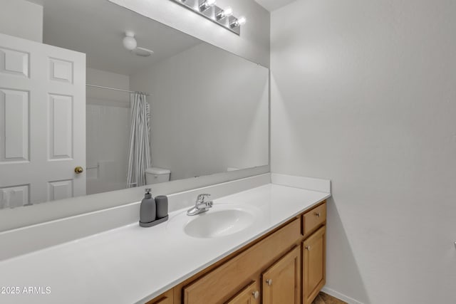 full bath featuring a shower with curtain, toilet, and vanity