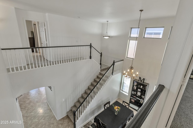 staircase featuring tile patterned floors and a notable chandelier