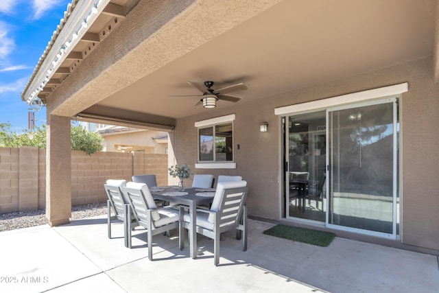 view of patio featuring outdoor dining area, fence, and ceiling fan