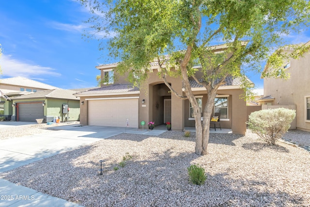 view of front of property featuring stucco siding, a tiled roof, and concrete driveway