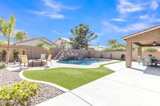 view of yard with a fenced in pool, a fenced backyard, a ceiling fan, a fire pit, and a patio area