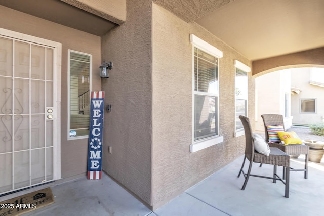 view of exterior entry featuring stucco siding and covered porch