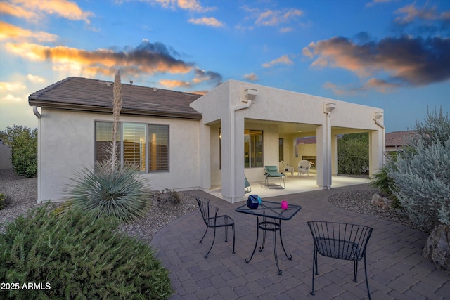 32128 S Bighorn Dr, Oracle, AZ 85623 - back of house at dusk with stucco siding and a patio area