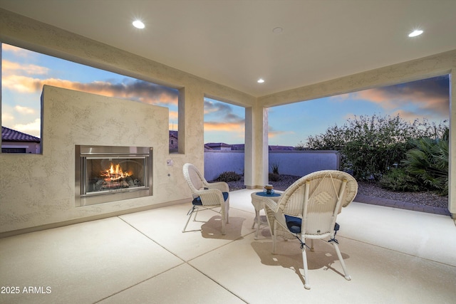 32128 S Bighorn Dr, Oracle, AZ 85623 - patio terrace at dusk with a warm lit fireplace and a patio area