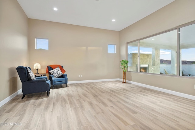32128 S Bighorn Dr, Oracle, AZ 85623 - unfurnished room featuring light wood-type flooring, a lit fireplace, and recessed lighting