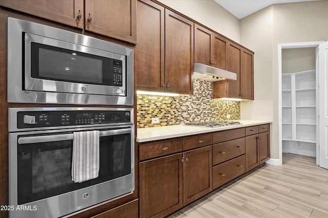 32128 S Bighorn Dr, Oracle, AZ 85623 - kitchen featuring appliances with stainless steel finishes, under cabinet range hood, light countertops, and decorative backsplash