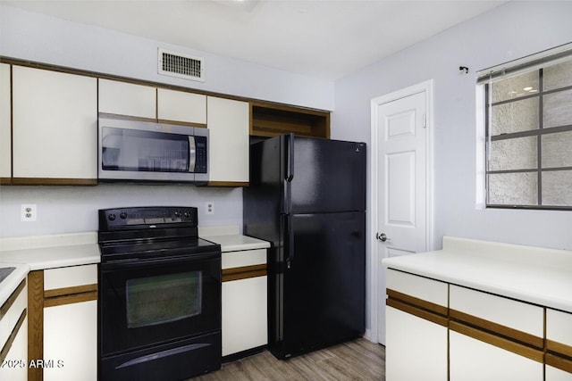 2333 E Southern Ave Unit 1015, Tempe, AZ 85282 - kitchen with black appliances, white cabinetry, light countertops, and light wood-style floors