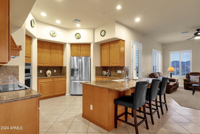 kitchen with ceiling fan, sink, backsplash, and appliances with stainless steel finishes