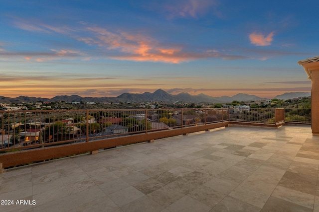 patio terrace at dusk featuring a mountain view