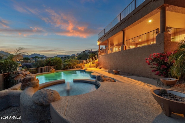 pool at dusk featuring a patio