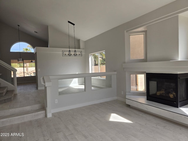 interior space featuring stairway, plenty of natural light, light wood-style flooring, and a multi sided fireplace