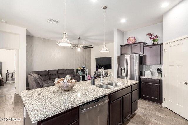 kitchen with dark brown cabinetry, a ceiling fan, visible vents, a sink, and stainless steel appliances