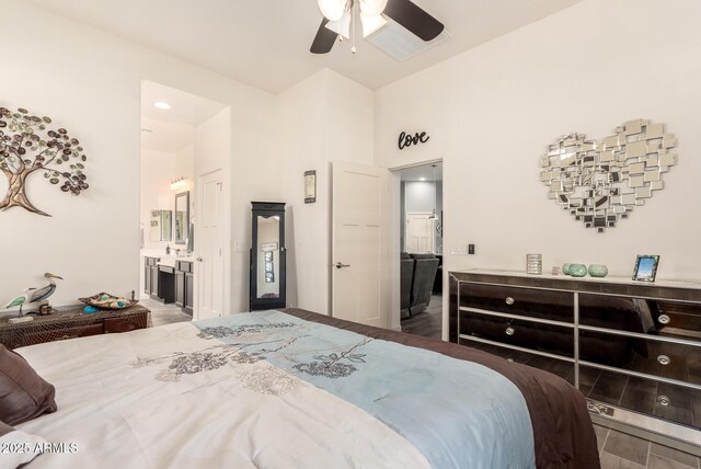 bedroom featuring wood finished floors, a ceiling fan, and ensuite bath