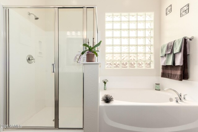 full bathroom featuring a shower stall and a bath