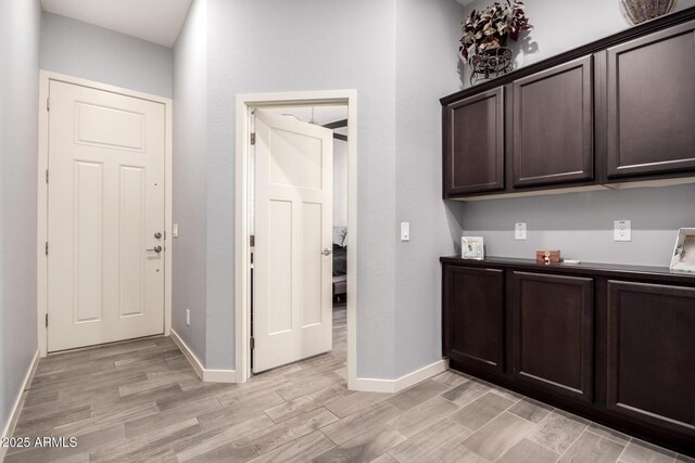 interior space featuring baseboards and light wood finished floors