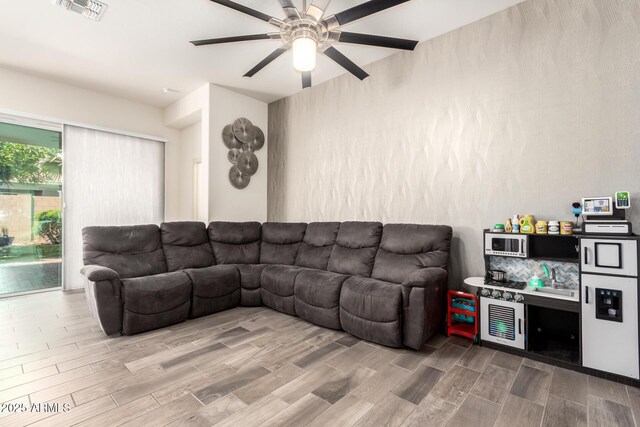 living room featuring visible vents, ceiling fan, and wood finished floors