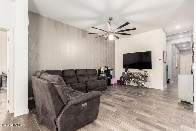 living area featuring a ceiling fan, baseboards, recessed lighting, wood finished floors, and visible vents
