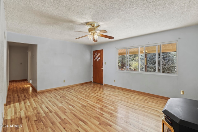 unfurnished living room featuring a textured ceiling, light wood-type flooring, and ceiling fan